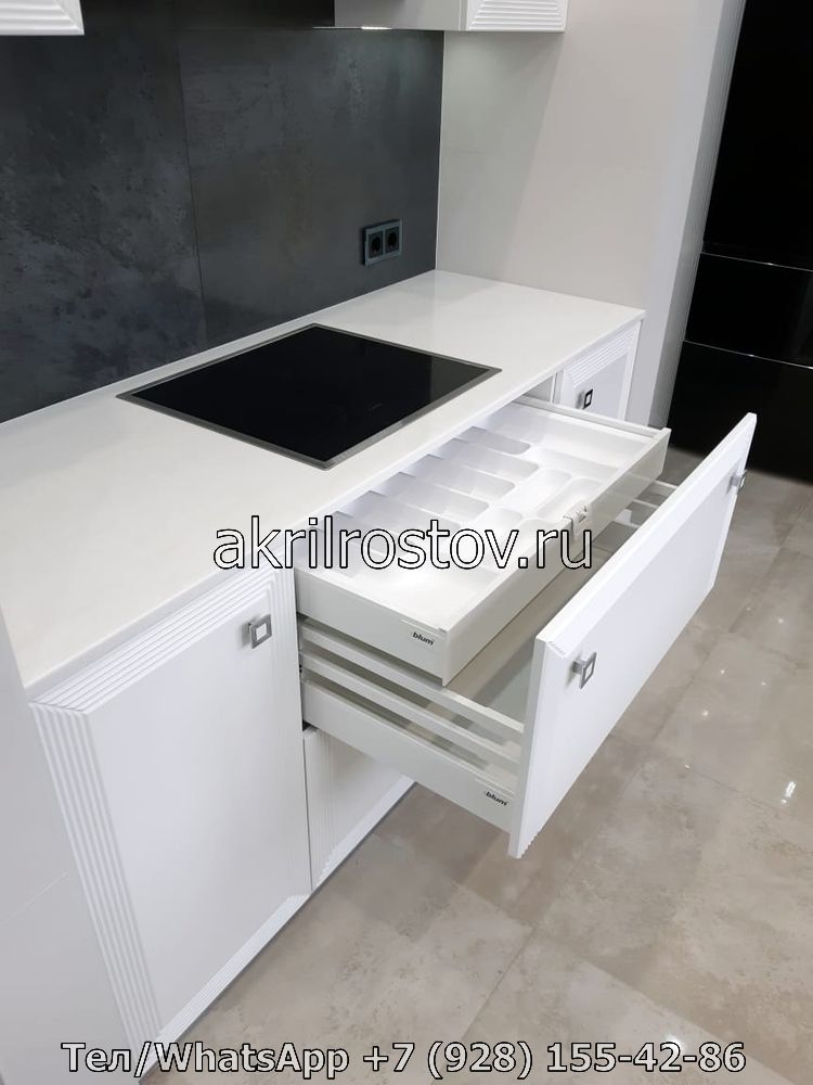 Современная рабочая зона с интегрированной плитой и вместительными ящиками из акрилового камня Кухонная поверхность из светлого искусственного камня с варочной панелью и выдвижными секциями